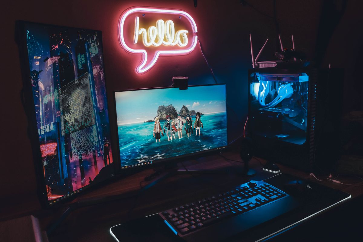 Gaming desk setup with neon lighting and dual monitors